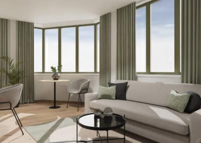 Sitzbereich im Erker eines Apartments in der Kohlgartenstraße mit hellgrünen Fensterrahmen und hellgrauen Möbeln